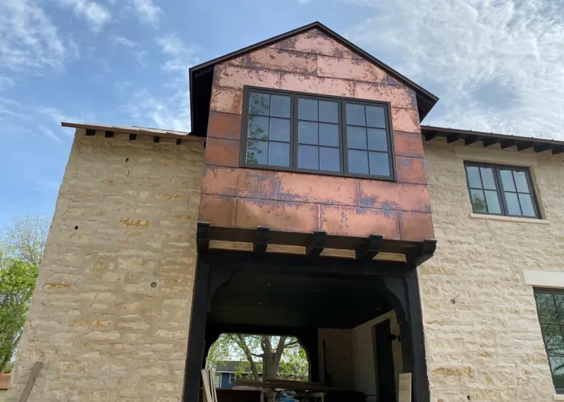 Copper metal panel facade on a stone building for Skylight Installation in Bethel